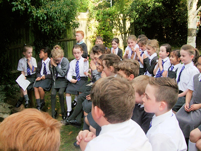 Children enjoying collective worship out of doors